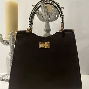 bebe Los Angeles Black purse with gold accents white and black braided handles.